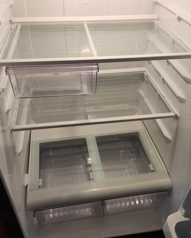 Refrigerator wiped clean inside, shelves and drawers shining